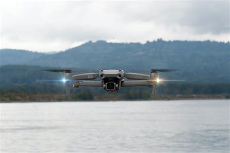 dji mini drone hovering above lake during sunset