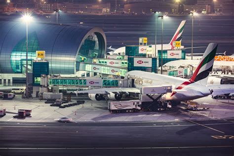 dubai airport night scene with multiple emirates aircraft on stand