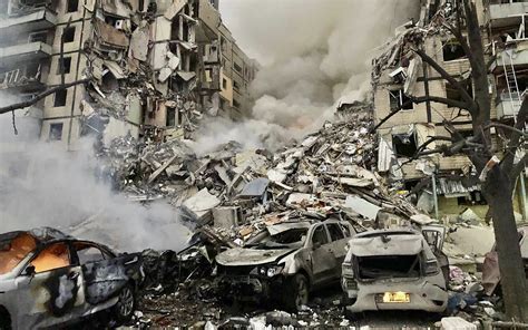 elderly civilian sifting through debris in Bilytske after missile strike
