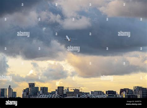 Embraer E190 descending steeply toward London City Airport above Canary Wharf skyline