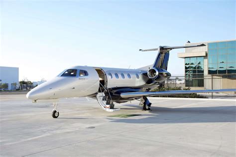 Embraer Phenom 300 private jet taxiing on tarmac in sunrise light