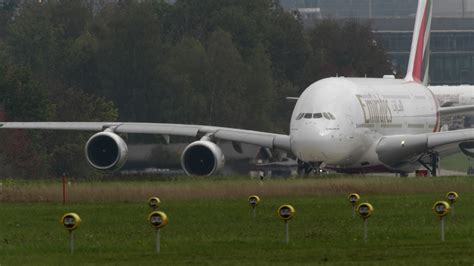 Emirates Airbus A380 taxiing at Hamburg Airport surrounded by ground crews