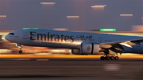 Emirates Boeing 777-300ER departing Dubai International Airport at sunset