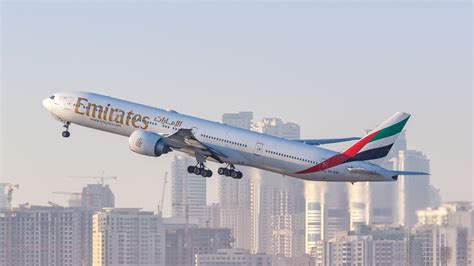 emirates boeing 777-300er over dubai skyline