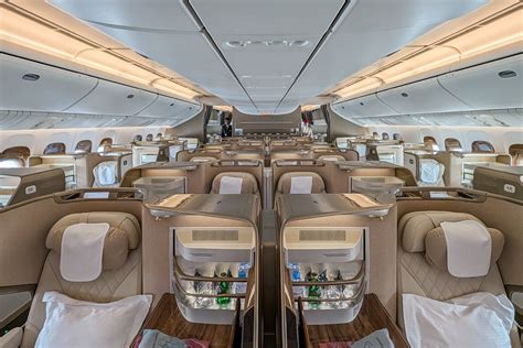 Emirates Boeing 777 business class cabin aisle perspective with soft lighting