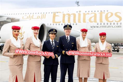 Emirates cabin crew standing beside Airbus A380 at Dubai International Airport
