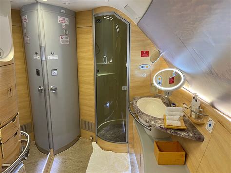 emirates first class shower spa with stocked amenities and glass door