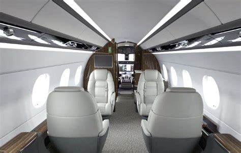 Empty cabin of a midsize jet highlighting luxury amenities and in-flight work setup