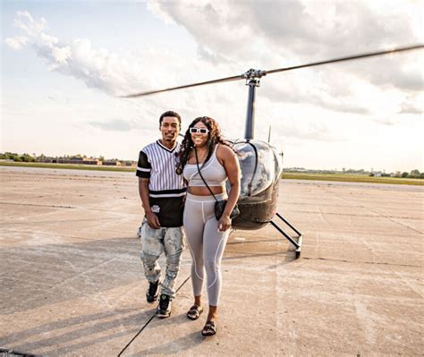 engaged couple in helicopter above Milwaukee skyline celebrating proposal