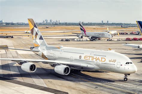 etihad aircraft parked at abu dhabi terminal at night