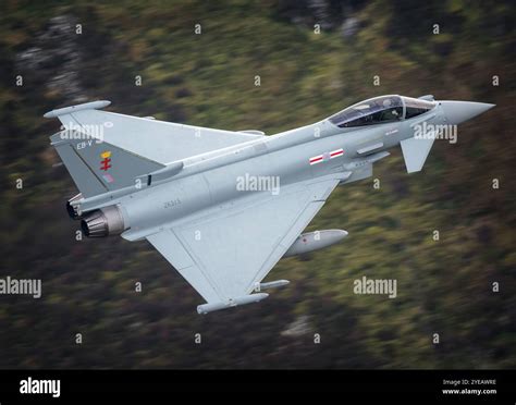eurofighter typhoon in low-level flight over arid terrain, loaded with air-to-air missiles