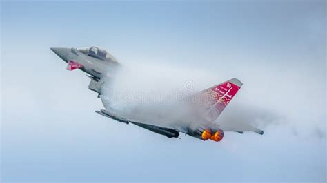 Eurofighter Typhoon performing high-G maneuver with vapor trails during airshow