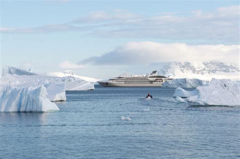 Expedition cruise ship anchored near towering icebergs in Antarctica’s Paradise Bay