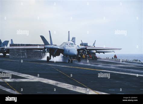 F-14 Tomcat launching from aircraft carrier deck at sea