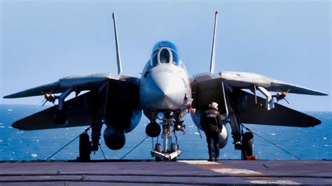 F-14 Tomcat parked on carrier deck wings swept back at sunset