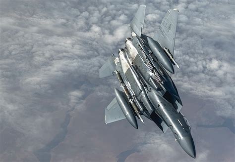 f-15 eagle in formation with visible insignia and full combat loadout