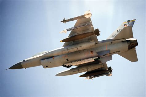 f-16 fighting falcon armed with missiles at sunset on runway