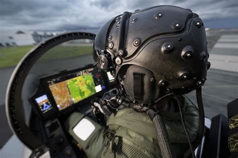 F-22 pilot wearing advanced helmet-mounted display visor in cockpit