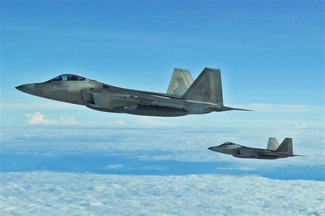 F-22 Raptor ascending vertically through low cloud cover