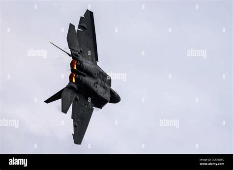 f-22 raptor banking in flight with weapons bay open mid-exercise