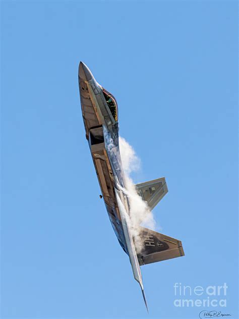 F-22 Raptor climbing into blue sky, showcasing twin-engine design and stealth silhouette