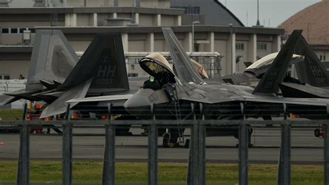 F-22 Raptor on runway with pilot preparing for mission