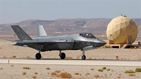 f-35 fighter jet on runway with maintenance crew