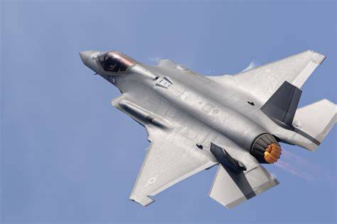 F-35 Lightning II fighter jet flying at high altitude above clouds