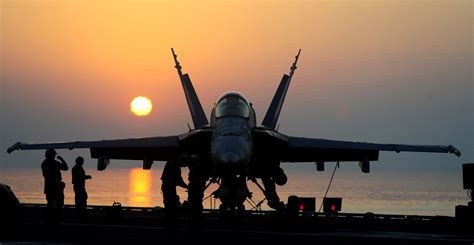 F/A-18 Hornet performing carrier landing at sunset