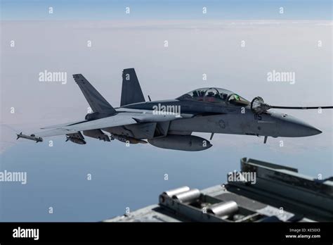 F/A-18 Hornet refueling mid-air with external ordnance loaded