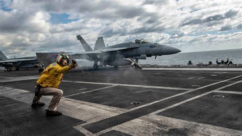 F/A-18 Super Hornet launching from aircraft carrier with full loadout