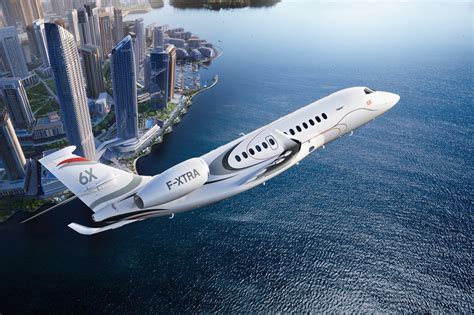 Falcon 6X in flight over a city skyline