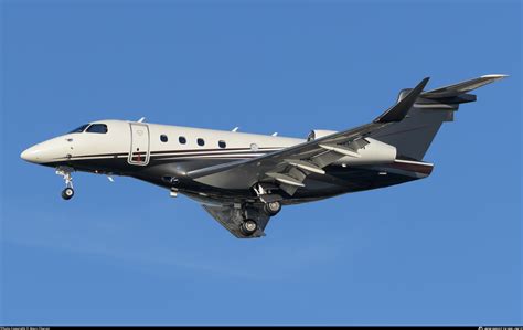 Flexjet Embraer Praetor 500 mid-flight above city skyline