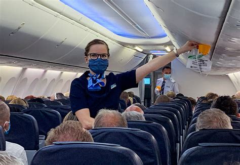 flight attendants performing cabin safety equipment checks before boarding