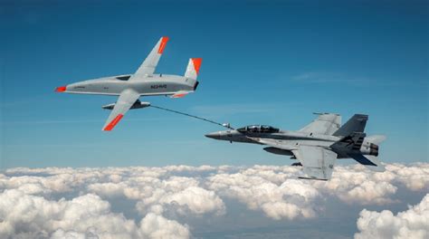 Flight deck operations on a US Navy aircraft carrier with F/A-18s and MQ-25 refueling drone