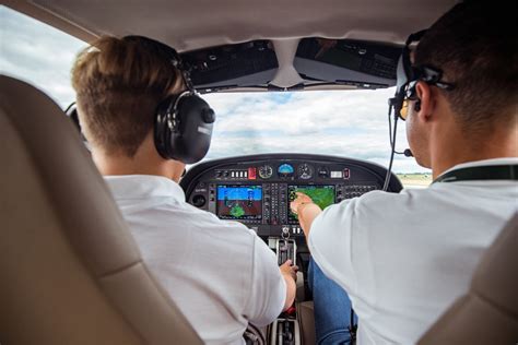 Flight instructor teaching student in helicopter above Front Range terrain