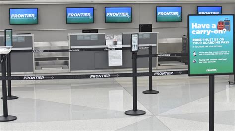 Frontier Airlines baggage drop counters with long lines of travelers at check-in