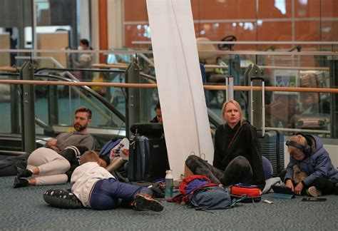 Frustrated travelers queuing at airline customer desk at Frankfurt Airport after mass cancellations