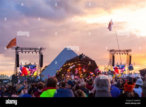 glastonbury crowd sunset with tents and main stage in distance