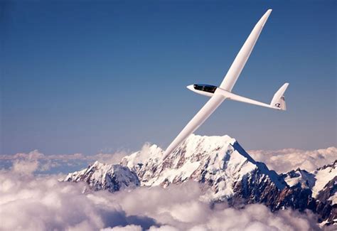 glider soaring high above a mountain range