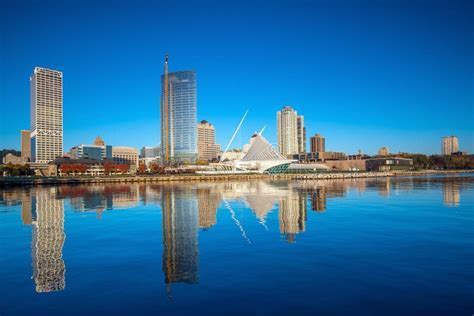 golden hour helicopter view of Milwaukee skyline with glowing lake reflection