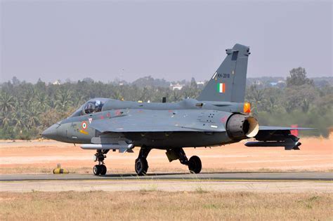 HAL Tejas undergoing high-G maneuver at airshow with afterburners flaring