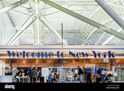 happy international tourists at JFK airport with welcome signage