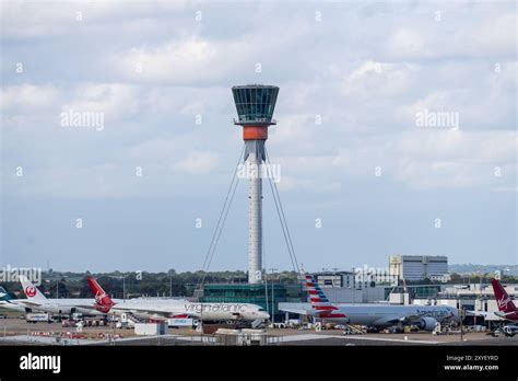 heathrow control tower at sunset with incoming aircraft