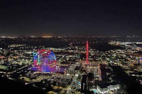 helicopter cockpit view flying over Christmas-lit theme parks in Orlando