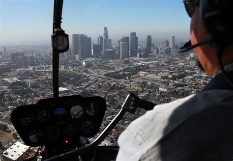 Helicopter flying above the Los Angeles skyline with Hollywood hills in background