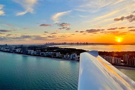 helicopter flying over Fort Lauderdale coastline at sunset with yachts visible below