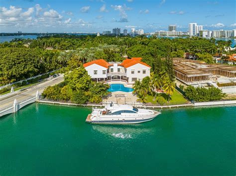 helicopter flying over star island homes with miami skyline in background