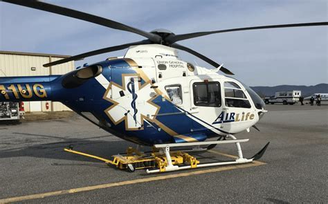 hospital helipad with emergency helicopter being maneuvered by chopper spotter