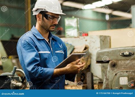 industrial maintenance engineer reviewing digital system performance dashboard on tablet in control room